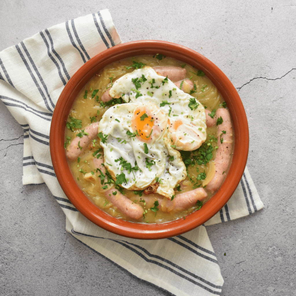 Salchichas blancas encebolladas con huevo frito